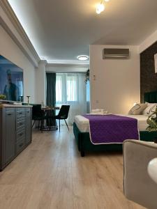a bedroom with a bed and a kitchen and a table at Lazar Towers Studios & Apartments near Palas in Iaşi