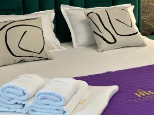 a bed with towels and pillows on it at Lazar Towers Studios & Apartments near Palas in Iaşi