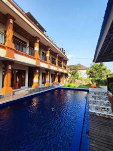 a hotel with a swimming pool in front of a building at Candra Loka Studio & Apartment by The Loka in Kerobokan