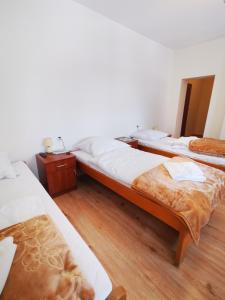 een slaapkamer met 2 bedden en een houten vloer bij Sanatorium "Dąbrówka" in Szczawno-Zdrój