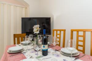 einen Tisch mit einer Flasche Wein und Gläsern darauf in der Unterkunft Apartments Zora in Lun