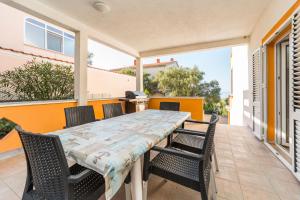 a table and chairs on the patio of a house at Apartments Zora in Lun