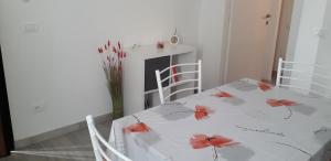 einen Esstisch mit roten Blumen darauf in der Unterkunft Casetta Monterano in Canale Monterano