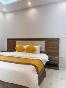 um quarto com uma cama grande e almofadas amarelas em سحاب em Iambo