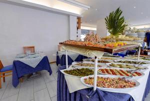 una línea de buffet con muchos tipos diferentes de comida en Hotel Margareth, en Riccione