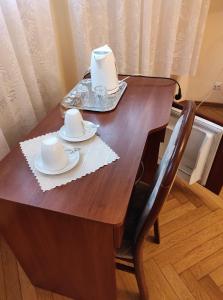 a wooden table with two hats and plates on it at Sanatorium "Dąbrówka" in Szczawno-Zdrój