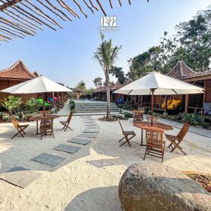 een patio met tafels, stoelen en parasols bij Point of View Hotel & Resort Majalengka in Majalengka