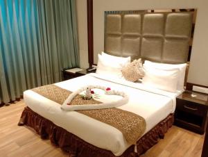 a bedroom with a large bed with a large headboard at The Stella Hotel & Resort in Ludhiana