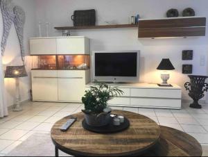 ein Wohnzimmer mit einem TV und einem Couchtisch in der Unterkunft Wohnung mit Whirlpool, Nähe Thülsfelder Talsperre in Cloppenburg