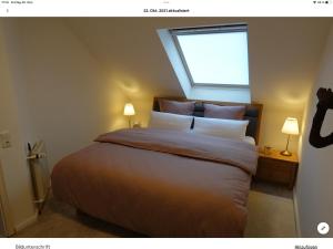 a bedroom with a bed with a window and two lamps at Wohnung mit Whirlpool, Nähe Thülsfelder Talsperre in Cloppenburg