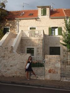 a woman standing in front of a building at Apartment Lasan in Vodice