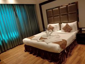 um quarto de hotel com duas camas com toalhas em The Stella Hotel & Resort em Ludhiana