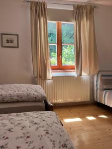 1 dormitorio con 2 camas y ventana en Ferienwohnung Waldhauser en Hermagor