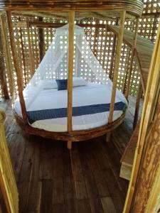 een bed in een bamboe hemelbed in een kamer bij Prince John beachfront cottages and Restaurant in San Vicente