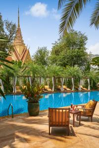 a swimming pool with two chairs and a resort at Palace Gate Hotel & Resort by EHM in Phnom Penh