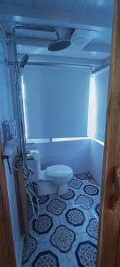 a bathroom with a toilet and a tile floor at familykomodocruise in Labuan Bajo
