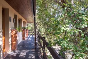 a wooden walkway next to a building with trees at Vallegrande Nature Resort by Geocharme in Cefalù