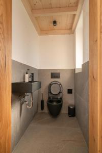 a bathroom with a black toilet and a sink at Chalet5 in Sankt Martin im Innkreis