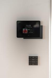 un televisor en una pared con un reloj en él en Chalet5, en Sankt Martin im Innkreis