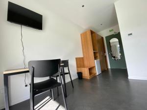 uma sala de estar com uma secretária e uma televisão na parede em Woodside Bed and Breakfast em Greytown