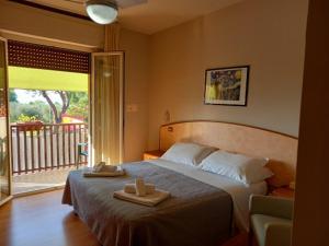 1 dormitorio con 1 cama con 2 toallas en Hotel Torricella, en Magione