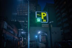un panneau de rue sur un poteau dans une ville la nuit dans l'établissement 银座合之屋 筑地市场地铁三分钟 银座徒步十分钟, à Tokyo