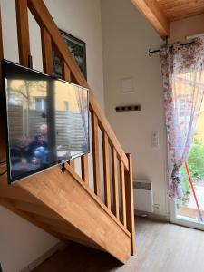 a living room with a flat screen tv on a staircase at Duplex terrasse in Frehel