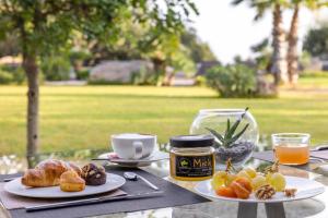 a table with two plates of food and a cup of coffee at Vallegrande Nature Resort by Geocharme in Cefalù