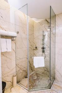 W łazience znajduje się prysznic ze szklanymi drzwiami. w obiekcie The Grand View Hotel Changzhou w mieście Changzhou