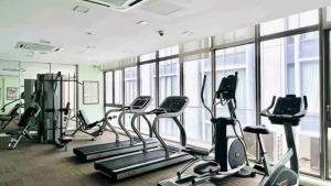 a gym with several treadmills and elliptical machines at Cosy Unit 5 min walk KL Pavilion KLCC by Elefen Homestay in Kuala Lumpur