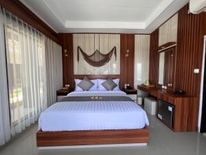 um quarto com uma cama grande e paredes de madeira em Grand Yuna Hotel Nusa Penida em Toyapakeh