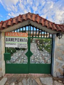 a green gate with a sign on top of it at Villa Dimitris near the beach! in Karavómilos
