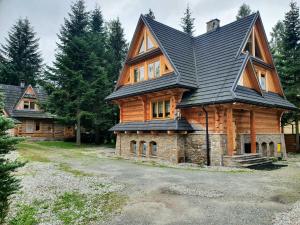 a large wooden house with a black roof at ZAKOPIANA in Zakopane