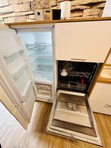 an empty refrigerator with its door open in a kitchen at FeWo Seeufer mit großem Garten in Goslar