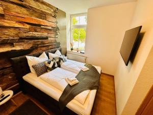 a bed in a room with a stone wall at FeWo Seeufer mit großem Garten in Goslar