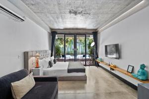 una camera con letto e divano di Balissimo Apartment by Hombali a Seminyak