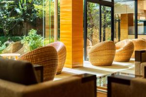 a row of wicker chairs in a room with windows at Hana Beppu in Beppu