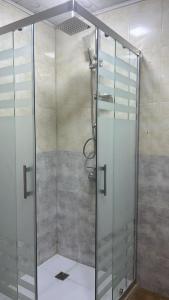 um chuveiro com uma porta de vidro na casa de banho em Spacious Rooms em Baku