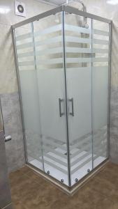 uma cabina de duche com portas de vidro na casa de banho em Spacious Rooms em Baku