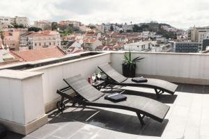 Duas cadeiras numa varanda com vista para a cidade em Hotel Lisboa em Lisboa