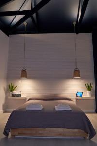 a bedroom with a large bed with two lights at #SimpliCity Modern Design Studio in Mytilene