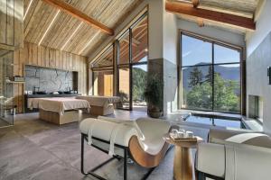 un salon avec une grande fenêtre et une baignoire dans l'établissement Pure Montagne Resort & Spa, à Saint-Martin-Vésubie