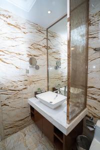 W łazience znajduje się umywalka i lustro. w obiekcie The Grand View Hotel Changzhou w mieście Changzhou