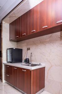 a kitchen with a sink and a microwave at The Grand View Hotel Changzhou in Changzhou