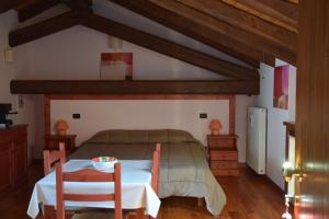 コルモンスにあるAgriturismo Domus Rusticaのベッドルーム1室(ベッド1台、テーブル、椅子付)