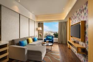 a living room with a couch and a tv at WOW Crest, Indore - IHCL SeleQtions in Indore