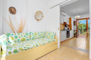 a living room with a couch and a kitchen at Villetta Bougainvillea in San Teodoro
