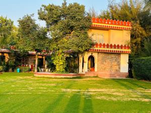 a house with an orange roof on a green yard at The Countryside Resorts Pushkar in Pushkar
