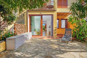 a house with two chairs sitting outside of it at Villetta Bougainvillea in San Teodoro