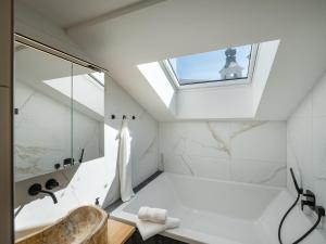 uma casa de banho com uma clarabóia e uma banheira de imersão. em Alpine Homes - Hopfgarten em Hopfgarten im Brixental